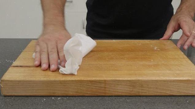 Risciacquare la tavola di legno sotto l'acqua calda per rimuovere eventuali residui di cibo